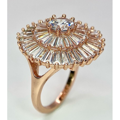 299 - A very fashionable cocktail ring, gold tone with cubic zirconia, presented in a hand carved stone tr... 