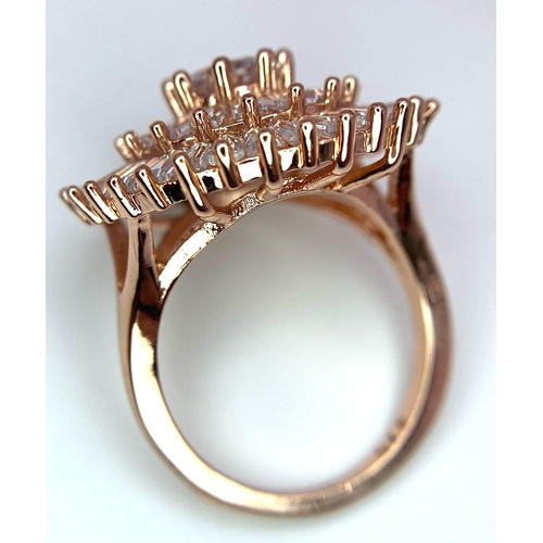 299 - A very fashionable cocktail ring, gold tone with cubic zirconia, presented in a hand carved stone tr... 