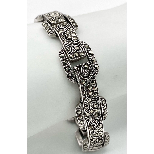 313 - A vintage, sterling silver bracelet, with an elaborate filigree design studded with marcasite. Hallm... 