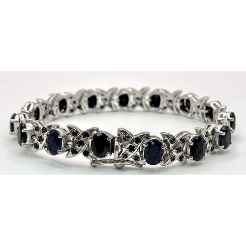 867 - An Oval Cut Blue Sapphire Tennis Bracelet set in 925 Sterling Silver. 33ctw. W-25g. 18cm length.