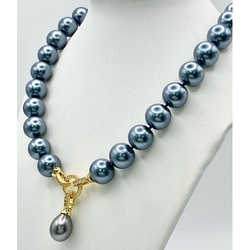 242 - A Metallic Grey South Sea Pearl Shell Necklace with a Teardrop Pendant. 14mm large beads. Gilded and... 