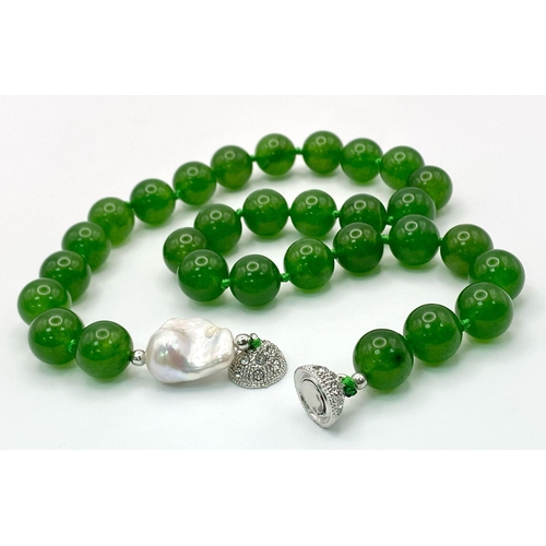 337 - A Fabulous Chinese Green Jade Bead Necklace with a Baroque Pearl Interrupter. 12mm jade beads. Fancy... 