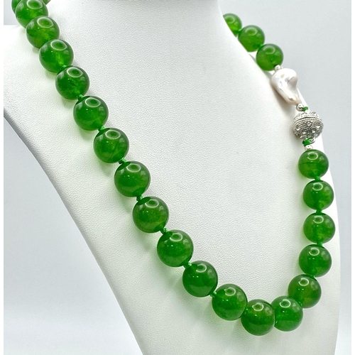 337 - A Fabulous Chinese Green Jade Bead Necklace with a Baroque Pearl Interrupter. 12mm jade beads. Fancy... 