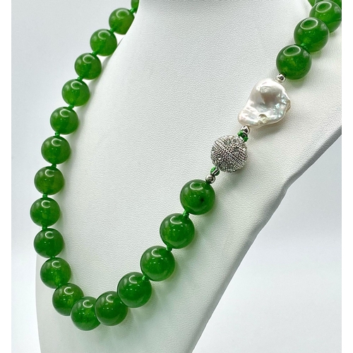 337 - A Fabulous Chinese Green Jade Bead Necklace with a Baroque Pearl Interrupter. 12mm jade beads. Fancy... 