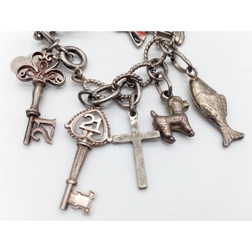 1470 - A vintage sterling silver charm bracelet with multiple charms such as wedding bell, cross, etc. Tota... 