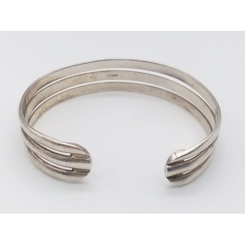 1653 - A STERLING SILVER TRIPLE BANDED BANGLE. 23.4G