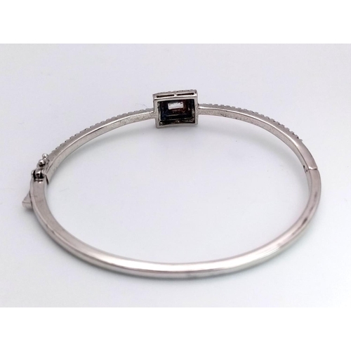 1659 - A STERLING SILVER STONE SET BANGLE. 12G