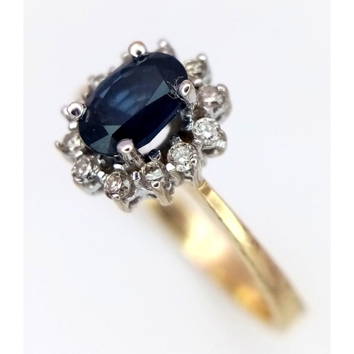 1581 - A 14K Yellow Gold Diamond and Sapphire Ring. Central oval cut sapphire with a diamond surround. Size... 