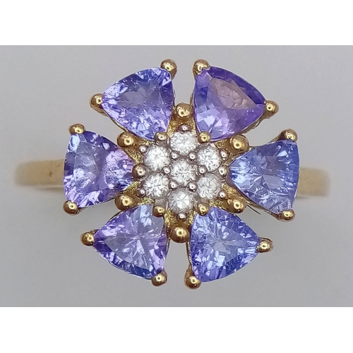 1637 - A 10K Yellow Gold Diamond and Tanzanite Floral Decorative Ring. Size R/S. 3.14g total weight.