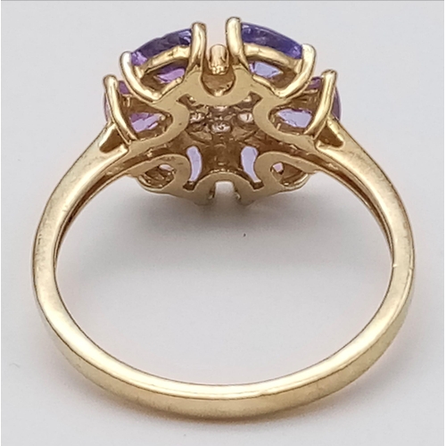 1637 - A 10K Yellow Gold Diamond and Tanzanite Floral Decorative Ring. Size R/S. 3.14g total weight.