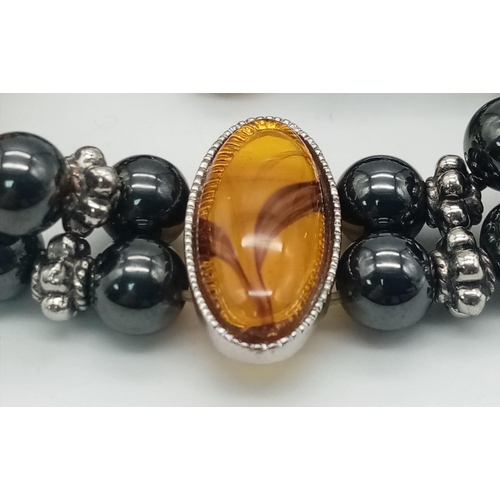 1164 - A stunning Haematite and Amber adjustable charm bracelet. Please see photos for details.