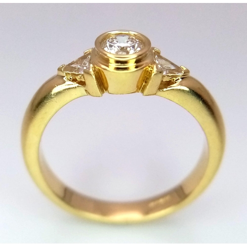 246 - An 18K Yellow Gold Diamond Ring. Central round cut diamond with trillion cut diamond accents. Size M... 