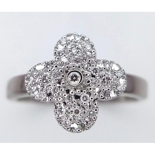 333 - A 18K WHITE GOLD CLOVER SHAPED 0.20CT DIAMOND SET RING. TOTAL WEIGHT 4.1G. SIZE M