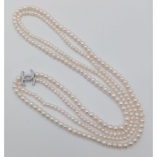 410 - A Long Double Row Cultured Pearl Necklace with a Silver CC Clasp. 80cm length.