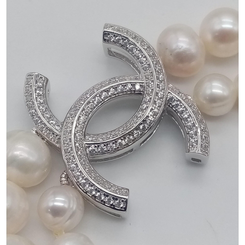 410 - A Long Double Row Cultured Pearl Necklace with a Silver CC Clasp. 80cm length.