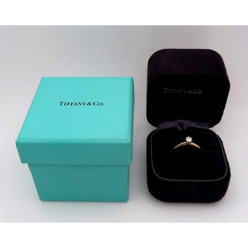 99 - A Tiffany and Co. 18K Yellow Gold Diamond Solitaire Ring. This VVS2 0.19ct brilliant round cut diamo... 