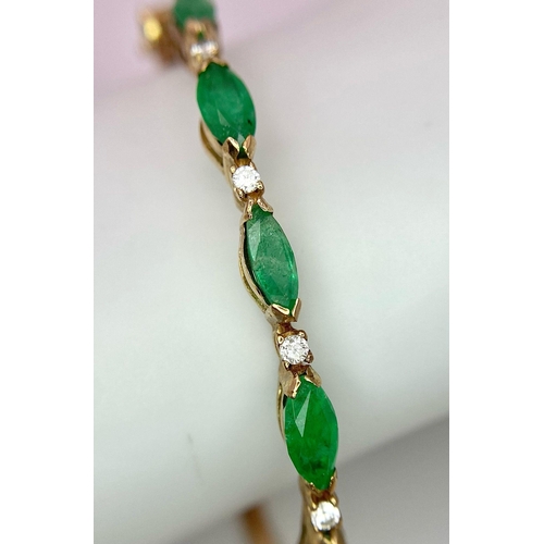 34 - A 9K Yellow Gold Emerald and Diamond Bangle. Six oval cut emeralds with five brilliant round cut dia... 