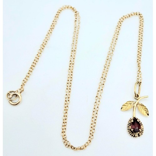 985 - A fancy 9K yellow gold Garnet flower pendant on delicate gold chain. Total weight 1.1G. Total length... 