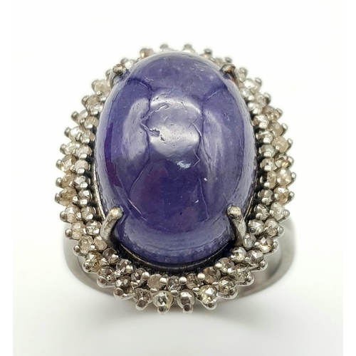 233 - A 12ct Tanzanite Cabochon Gemstone ring with a 1.2ctw Double Diamond Halo. Set in 925 silver. Size O... 