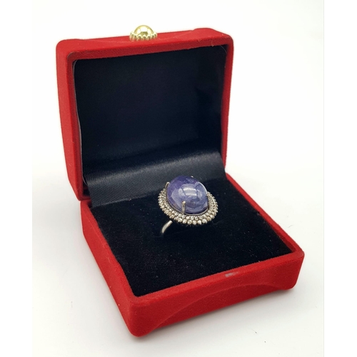 233 - A 12ct Tanzanite Cabochon Gemstone ring with a 1.2ctw Double Diamond Halo. Set in 925 silver. Size O... 