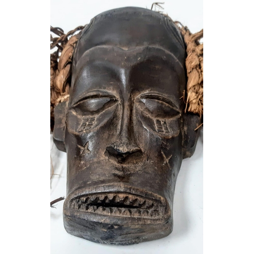 1535 - An antique Maasai wooden mask of a young warrior with red long “hair”. In very good condition for it... 