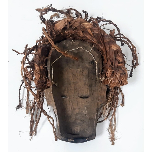 1535 - An antique Maasai wooden mask of a young warrior with red long “hair”. In very good condition for it... 