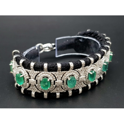 12 - An Asian Inspired Emerald and Diamond Bracelet set in a Woven Black Textile. 10ctw of oval cut emera... 