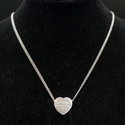 443 - A Sterling silver Tiffany and Co double chain necklace with engraved heart pendant. Comes complete w... 