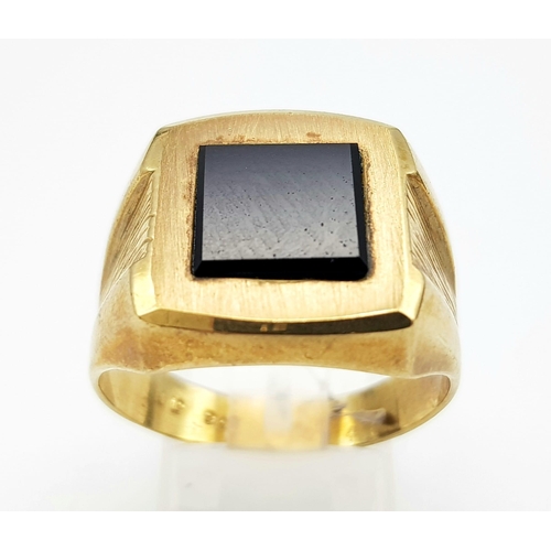 80 - A GENTS 9K GOLD SIGNET RING WITH SQUARE BLACK ONYX CENTRE STONE AND BARKED EFFECT ON SHOULDERS .   6... 