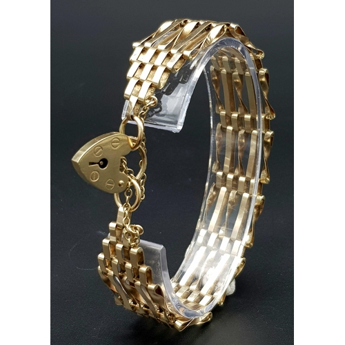 810 - A 9K GOLD 8 GATE BRACELET WITH HEART PADLOCK AND SAFETY CHAIN. .   12.4gms