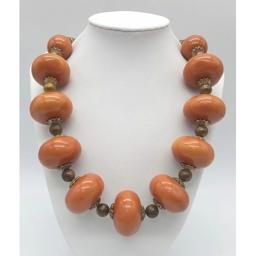 1808 - An Amber Resin Large Rondelle Necklace. 48cm