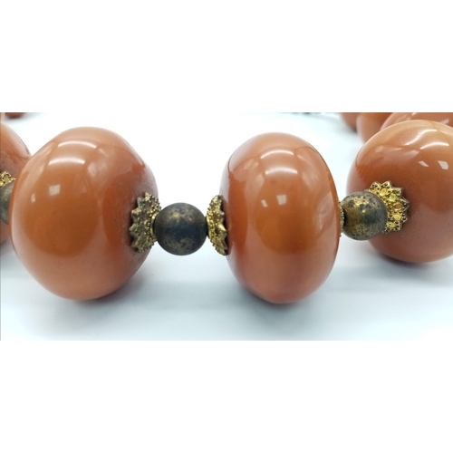 1808 - An Amber Resin Large Rondelle Necklace. 48cm