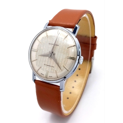 621 - A Vintage Newmark Gents Watch. Brown leather strap. Stainless steel case - 33mm. Textured white dial... 