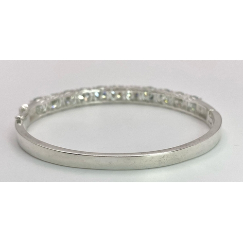 935 - An 11ctw White Moissanite Bracelet set in 925 Silver. Clip open. 6cm inner diameter. 13.5g weight. R... 