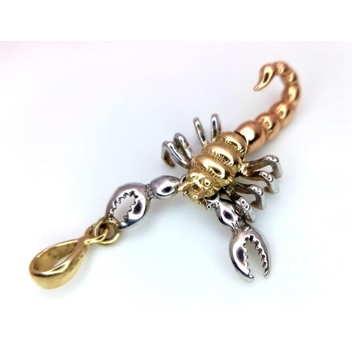 390 - A 14K 2 COLOUR GOLD ARTICULATED SCORPION CHARM / PENDANT. TOTAL WEIGHT 2.9G