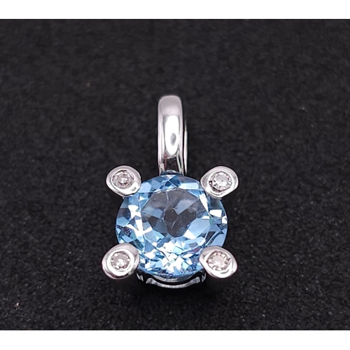 562 - A 18K WHITE GOLD DIAMOND & BLUE TOPAZ PENDANT. TOTAL WEIGHT 1.1G