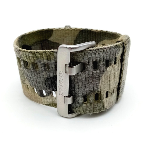 1398 - A Men’s Nixon Military Watch. 38mm Including Crown on Camouflage Combat Strap. Scout Model. Full Wor... 