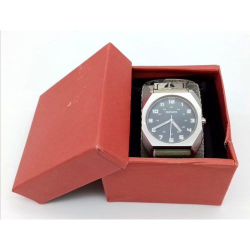 1398 - A Men’s Nixon Military Watch. 38mm Including Crown on Camouflage Combat Strap. Scout Model. Full Wor... 