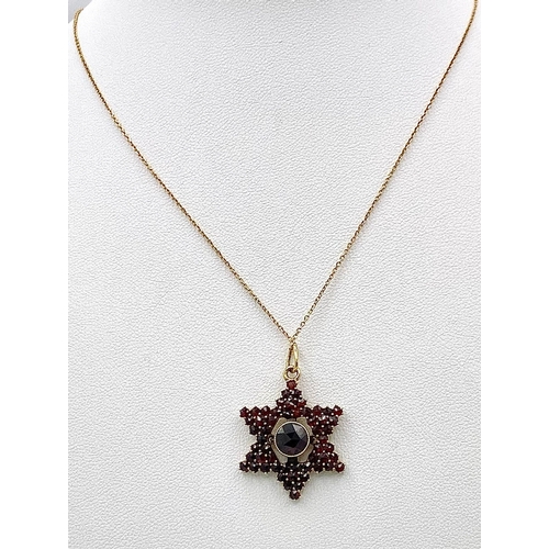 661 - A 14K Gold and Garnet Star Pendant on an 18K Yellow Gold Disappearing Necklace. 3cm and 44cm.4.5g to... 