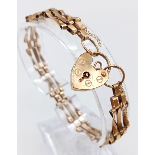 767 - A 9K GOLD 9 GATE BRACELET WITH HEART PADLOCK AND SAFETY CHAIN .    7.2gms