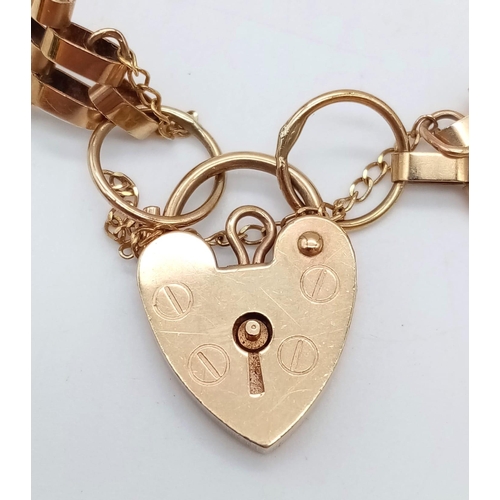 767 - A 9K GOLD 9 GATE BRACELET WITH HEART PADLOCK AND SAFETY CHAIN .    7.2gms