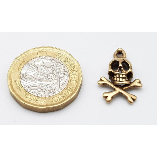 817 - A 9K YELLOW GOLD SKULL & CROSSBONES CHARM. TOTAL WEIGHT 1.8G