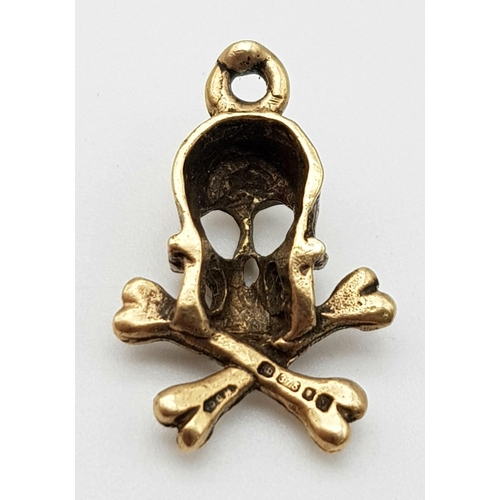 817 - A 9K YELLOW GOLD SKULL & CROSSBONES CHARM. TOTAL WEIGHT 1.8G