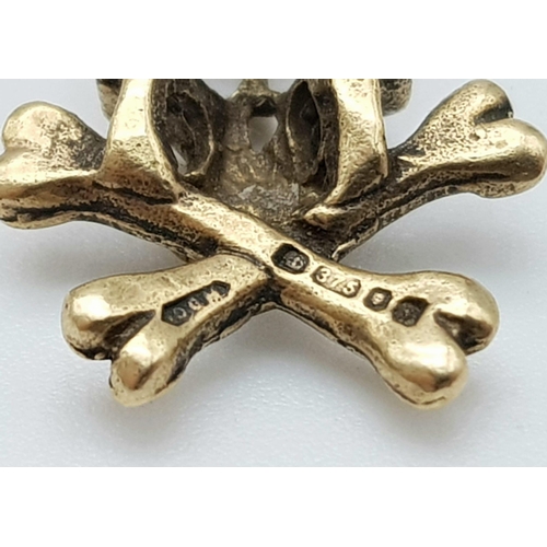 817 - A 9K YELLOW GOLD SKULL & CROSSBONES CHARM. TOTAL WEIGHT 1.8G