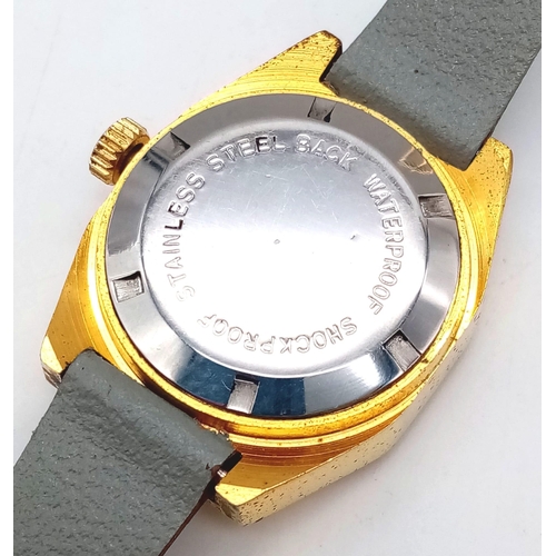 1061 - A Vintage Omax 17 Jewel Jump Ladies Watch. Grey leather strap. Gilded case - 26mm. Gold tone dial wi... 