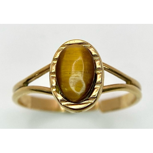 1179 - A 9K GOLD ADJUSTABLE RING WITH TIGERS EYE STONE .   2.4gms     one size