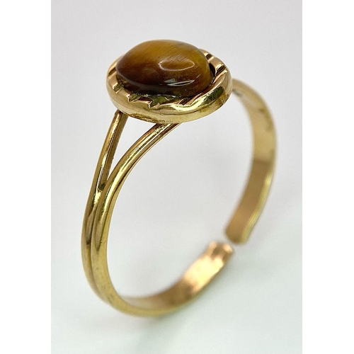 1179 - A 9K GOLD ADJUSTABLE RING WITH TIGERS EYE STONE .   2.4gms     one size