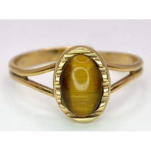 1179 - A 9K GOLD ADJUSTABLE RING WITH TIGERS EYE STONE .   2.4gms     one size