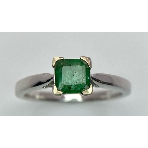 1186 - AN 18K WHITE GOLD RING WITH SQUARE EMERALD CENTRE STONE .   3.3gms   size N