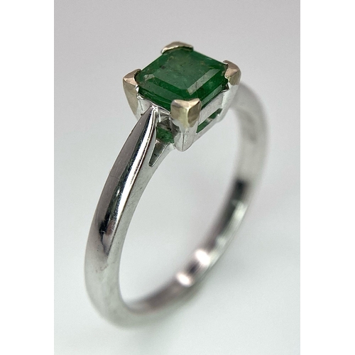 1186 - AN 18K WHITE GOLD RING WITH SQUARE EMERALD CENTRE STONE .   3.3gms   size N